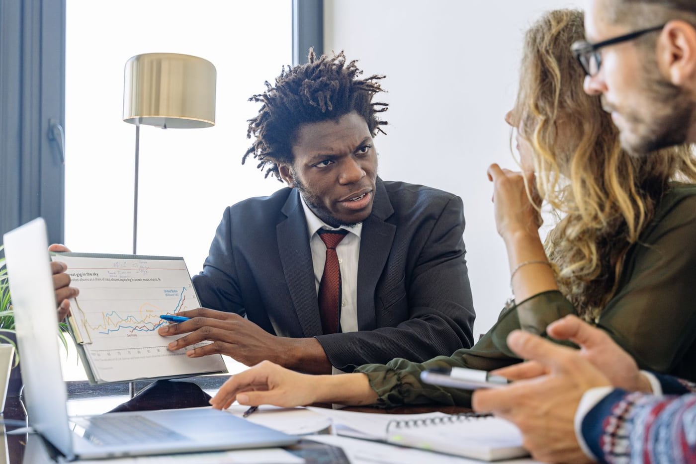 Business adviser and clients discussing documents at an office meeting