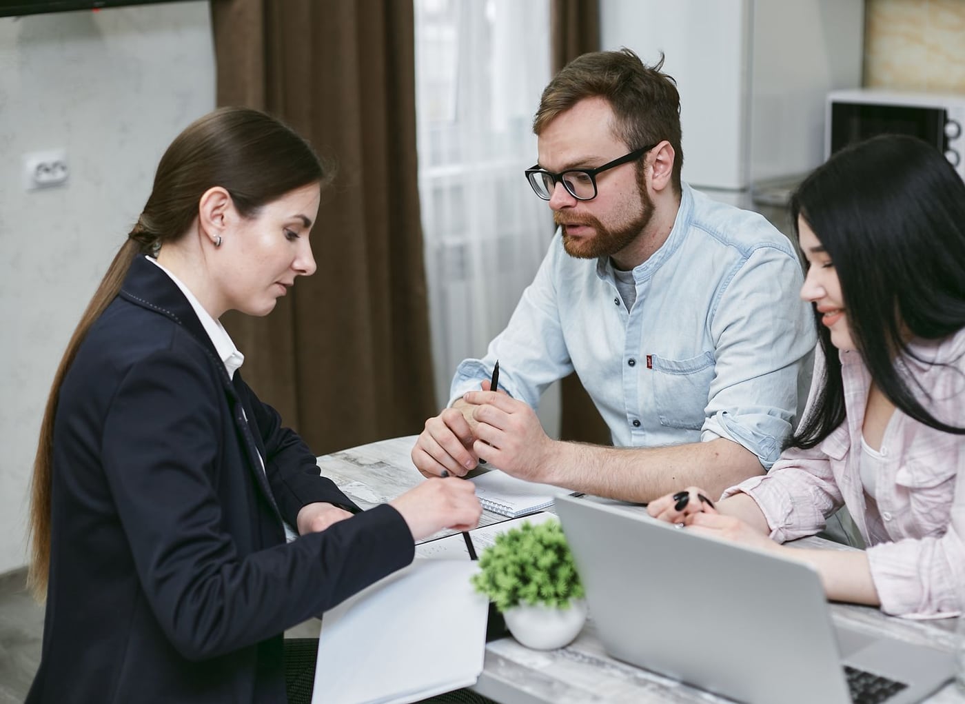 Couple reviewing financial documents with an adviser