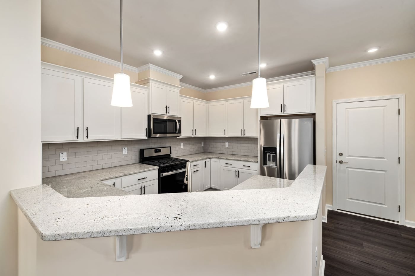 Finished kitchen with white cabinets and stainless steel appliances