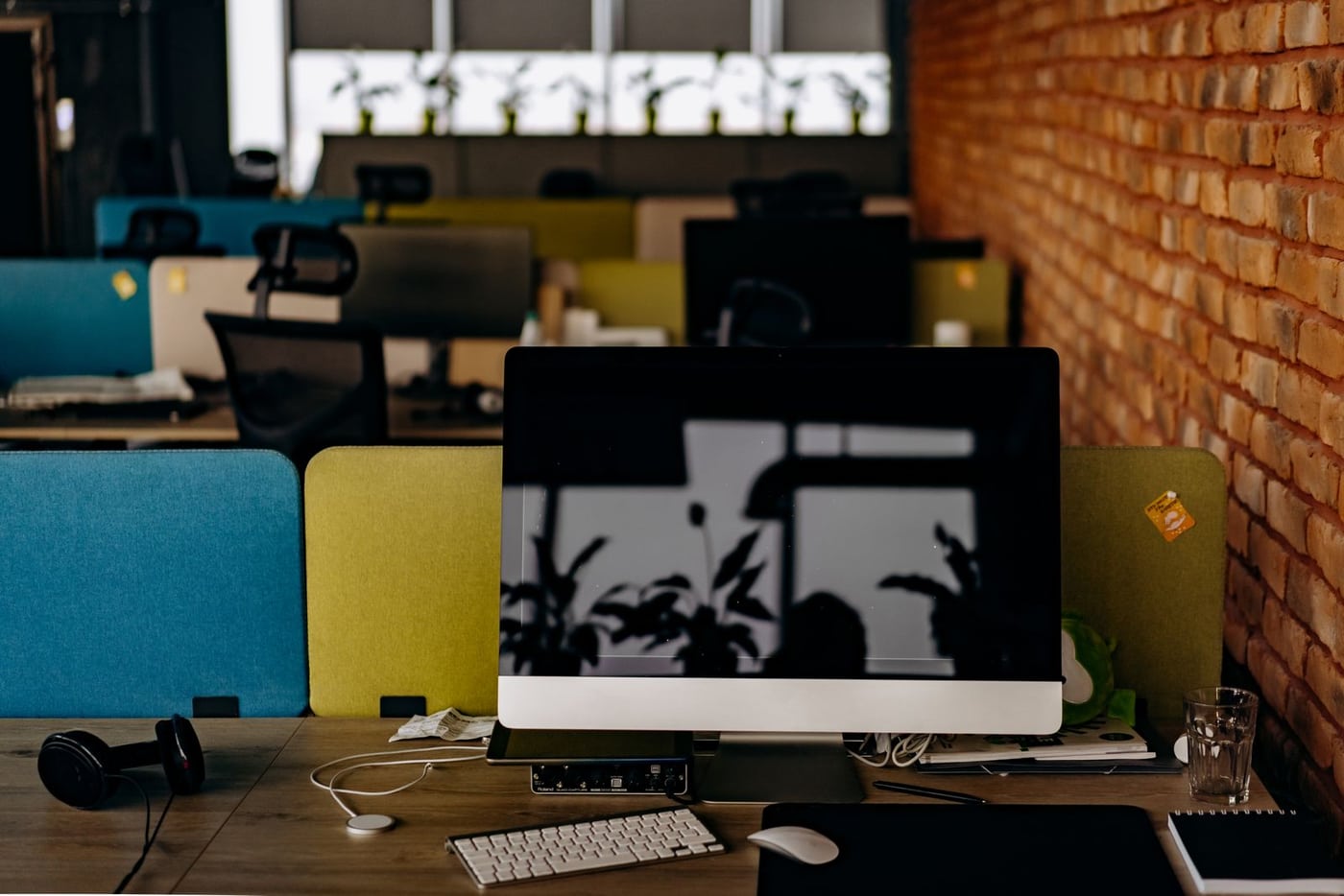 Office workstation with a computer, notebook and plant