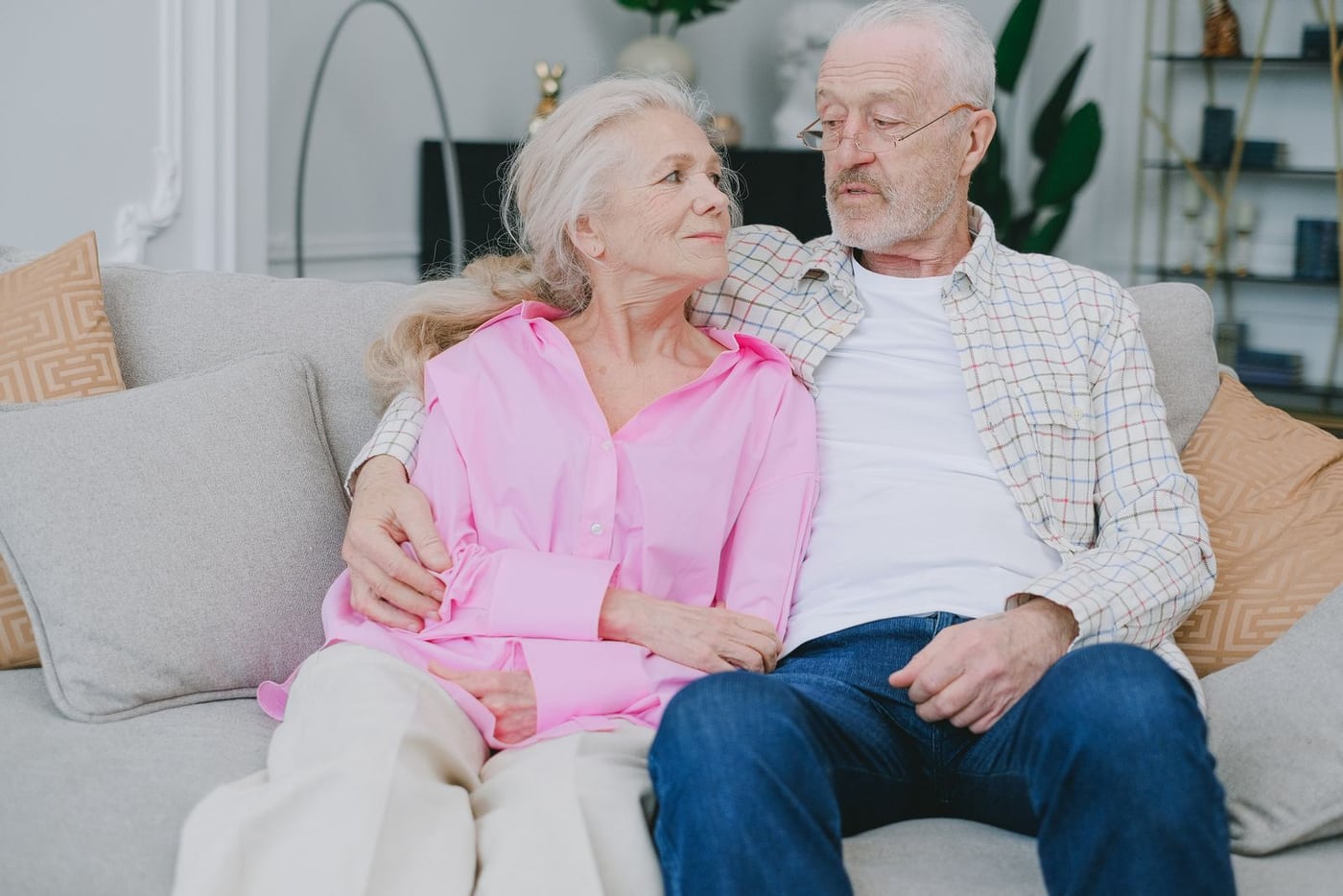 Older couple embracing on a sofa in their living room