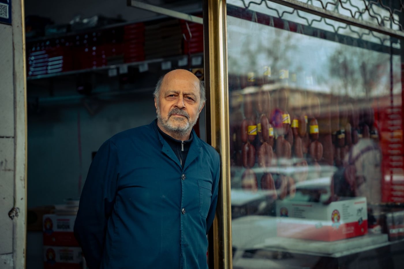 Shop owner standing beside his storefront
